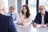 three people sit in a panel facing one person